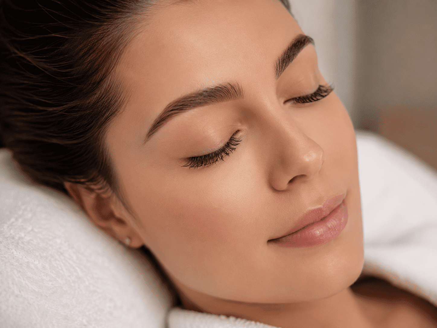 Young woman with flawless skin relaxing with eyes closed.